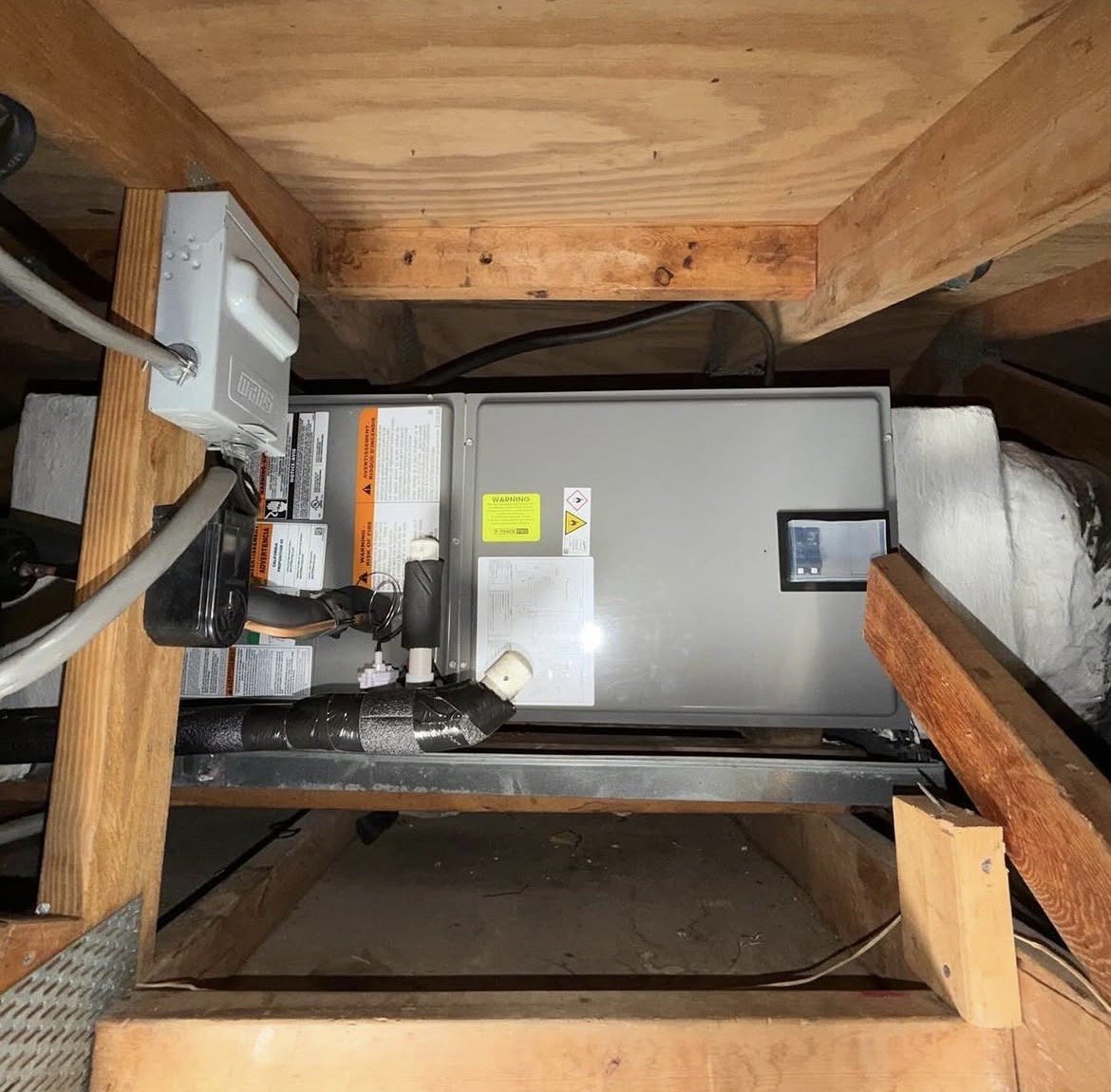 Attic air handler installed between roof framing