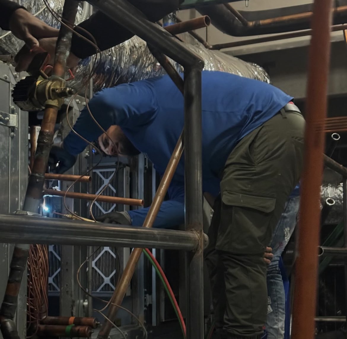 Technician working on commercial HVAC piping