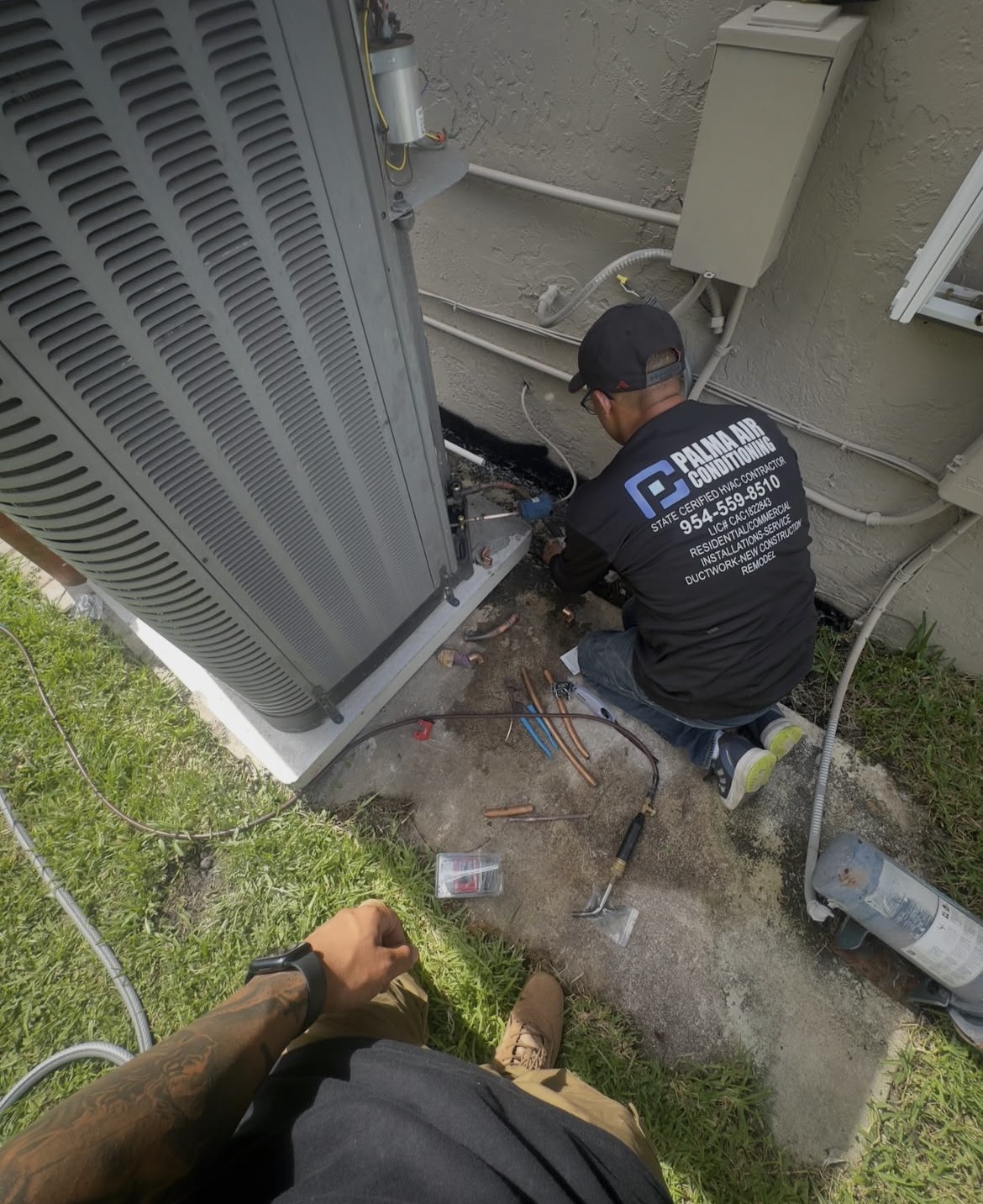 Technician servicing residential condenser