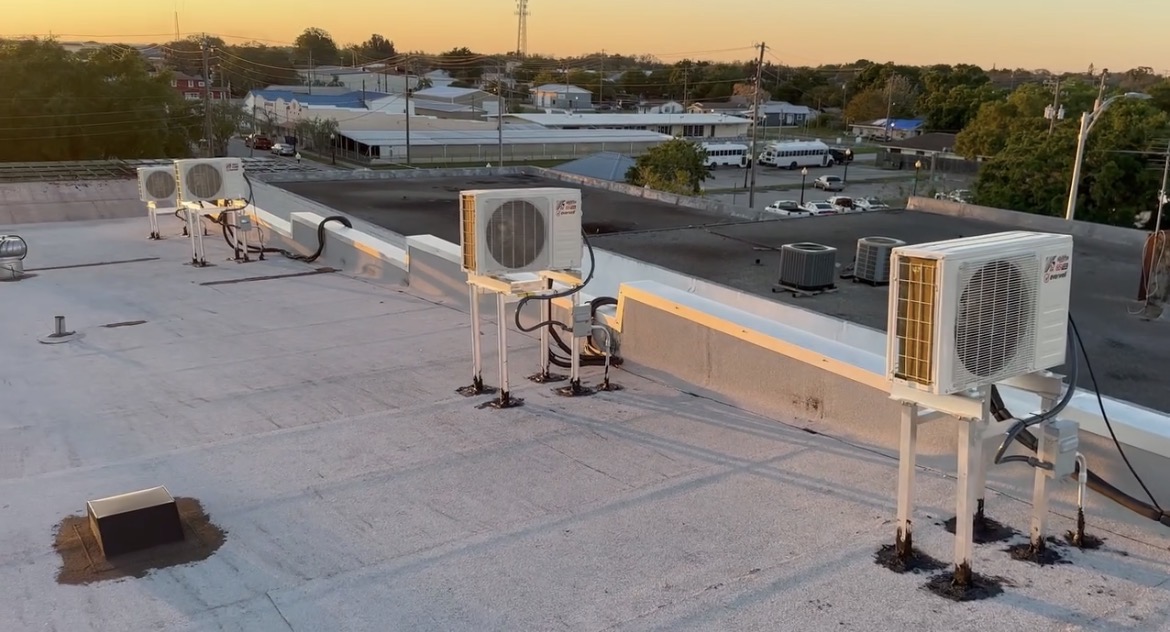 Rooftop mini-split condenser installation at sunset